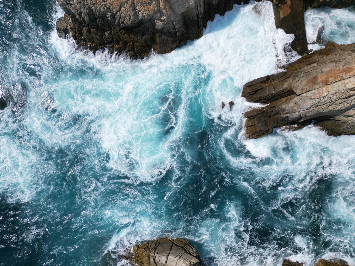 Olas rompiendo contra las rocas vistas desde un dron
